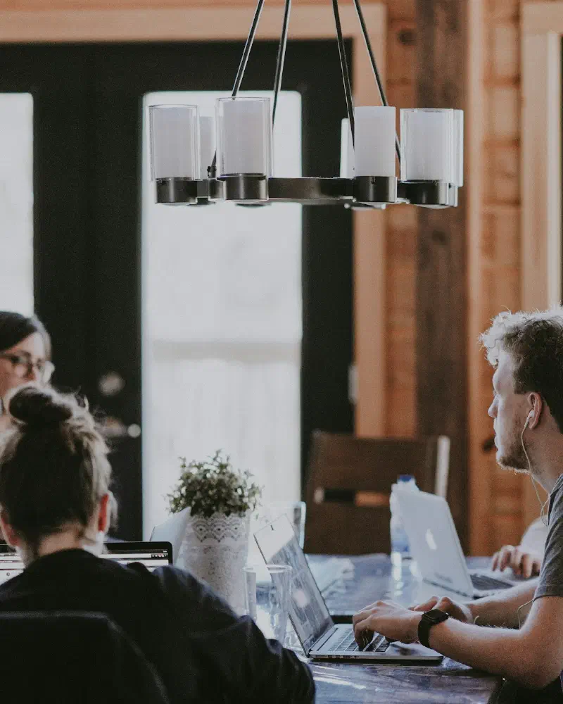 A team working together on laptops at a long table